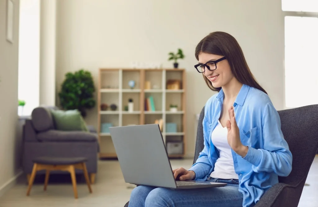 Professional woman using laptop and confidently following our virtual interview tips during an online meeting.