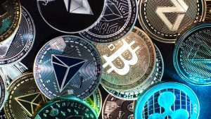 Various cryptocurrency coins including Bitcoin, Ethereum, and Ripple, representing the growing need for crypto compliance in digital assets.